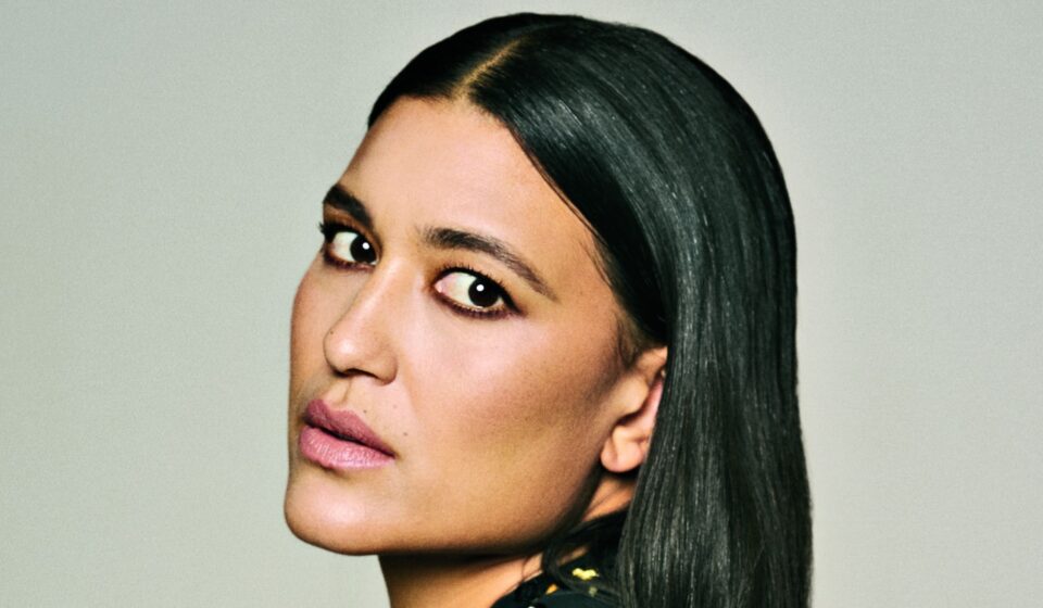 Close-up portrait of Julia Jones with sleek, side-parted black hair, softly smoky eye makeup and muted pink lipstick.